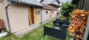 an empty yard with two chairs and a house at Ubytovanie Harmony House in Veľký Meder