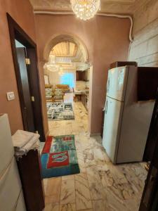 a kitchen with a refrigerator and a living room at شقة مفروشة في البنيات - بالقرب من جامعة البتراء in Amman