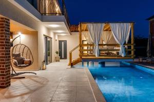 a swimming pool in a villa with a house at Villa Alba ZadarVillas in Vrana