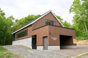 二世古Uli Villa Onsen的一座大型棕色建筑,设有车库
