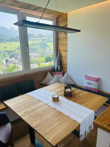 a wooden table in a room with a large window at Alpenblick - klein, aber fein in Schladming