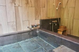 a bathroom with a tub with a water fountain at Uli Villa Onsen in Niseko +16 photos