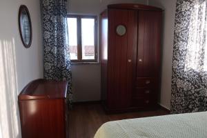 ein Schlafzimmer mit einem Bett, einer Kommode und einem Fenster in der Unterkunft Cosy 3 bedroom house close to the beach in Vila Praia de Âncora