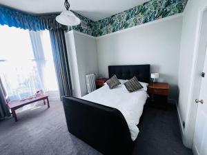 a bedroom with a bed with a black headboard at Lambert House in Hull
