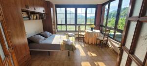 a bedroom with a bed and a table and windows at Casa Luisín Jacuzzi exterior Casa completa 10 personas in El Pino