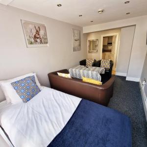 a bedroom with a bed and a couch in it at City Center Ground Floor Flat With Patio &parking in Norwich