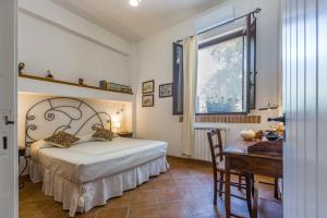 a bedroom with a bed and a desk and a window at Villa Oceri Gioiosa Marea in Gioiosa Marea