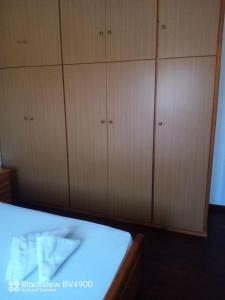 a bedroom with wooden cabinets and a white bed at Evangelia's House - Plaka Limnos in Pláka +23 photos