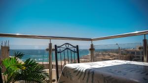 Tamraght OuzdarにあるAppartement Bord de Mer - Banana Beachの市街の景色を望むバルコニー(ベッド付)