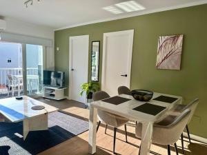 a dining room with a white table and chairs at Edf. 4 caminos in Nerja +33 photos