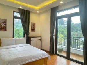 a bedroom with a bed and a large window at AnAn VILLA in Khu Chi Lăng