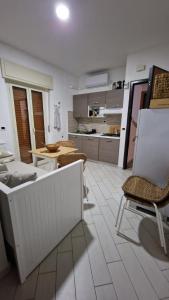 a living room with chairs and a table and a kitchen at Apartman SOFIA - close to the railway station in Scalea