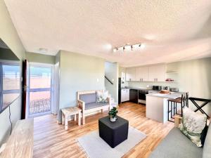 an open living room with a kitchen and a table at Fijnbosch Villa at Claptons in Jeffreys Bay
