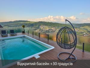 a swing on a deck next to a swimming pool at Villas Fomich in Bukovel