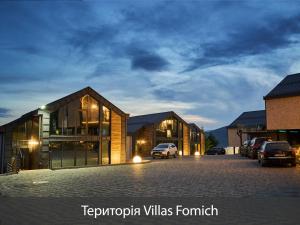a group of buildings with cars parked in a parking lot at Villas Fomich in Bukovel +68 photos