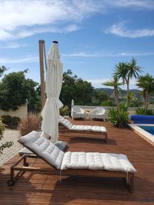 two lounge chairs and an umbrella on a wooden deck at Casa Bella Studio in São Brás de Alportel