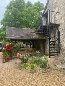 un edificio con una scala, una panchina e dei fiori di Sunflower Cottage a Genneteil