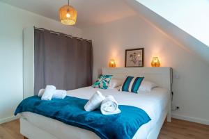 Un dormitorio con dos camas con sábanas azules y blancas. en Le Haut du Nelud - Appt dans maison avec jardin, en Locmariaquer