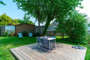 una mesa y sillas en una terraza en un patio en Le Haut du Nelud - Appt dans maison avec jardin, en Locmariaquer