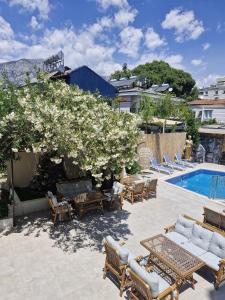 a patio with a tree with white flowers next to a pool at Vois Kemer Hotel in Kemer