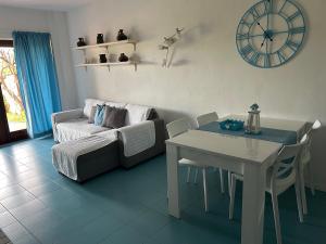 a living room with a table and a couch at Casa azzurra Salina Bamba in Punta Molara