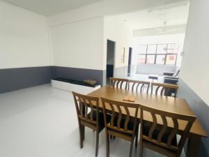a dining room with a wooden table and chairs at Singtown Guesthouse in Mersing