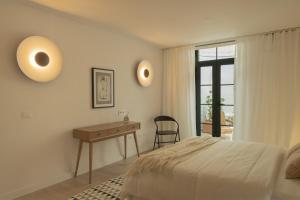 a bedroom with a bed and a desk and a window at Almaré in Los Llanos de Aridane