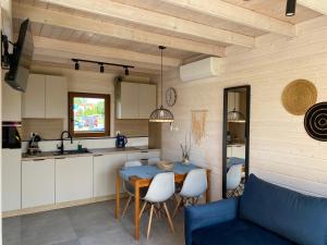 a kitchen and dining room with a table and chairs at KORALIA Domki Standard z basenem in Sarbinowo