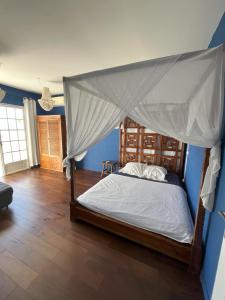 Saint-PaulにあるVilla Mahé 8 personnes avec piscine et vue merの天蓋付きベッドのある寝室