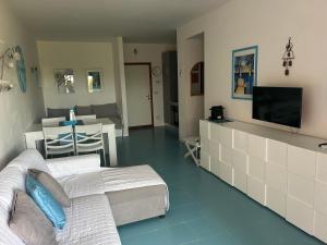 a living room with a bed and a television at Casa azzurra Salina Bamba in Punta Molara