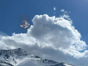 a cloud in the sky over a snow covered mountain at Ecomama in Xınalıq Khinalig guest house in Quba