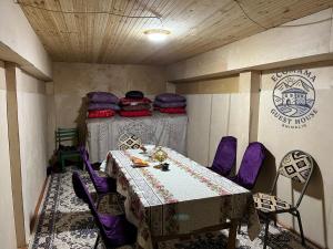 a room with a table and purple chairs in a room at Ecomama in Xınalıq Khinalig guest house in Xınalıq