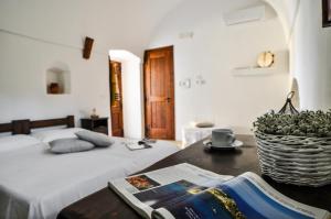 a bedroom with a bed and a table with a magazine at Masseria Uccio in Tricase