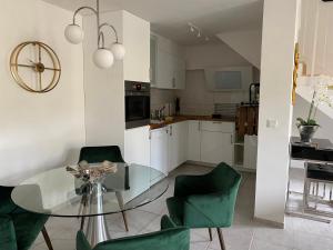 a kitchen with a glass table and green chairs at Rheinblick Apartments in Cologne