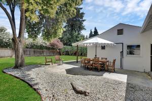 a patio with a table and a white umbrella at A Cozy Home | Games | Dogs OK in Yuba City