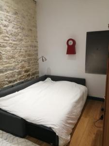 a bed in a room with a brick wall at Loft ViaRhôna, Grand loft en Centre-Ville in Lyon
