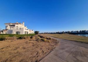 a house on a hill next to a road at Beautiful views lake golf house in Roldán