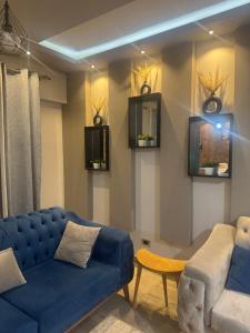 a living room with a blue couch and a chair at البيت بيتك الواحة in 6th Of October