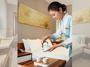 Deacon House Wuxi في ووشي: امرأة تصب القهوة في أكواب في غرفة الفندق