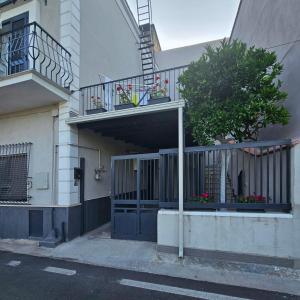 a building with a gate and a balcony with flowers at Giuius home Apartment in Camposano