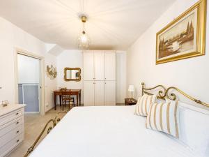 a white bedroom with a bed and a table at Oasi di pace 2 in Montalbano +32 photos