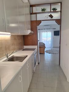 a kitchen with white cabinets and a sink at Salt & Pine in Kallithea Halkidikis