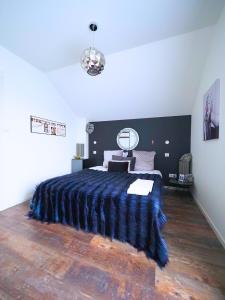 a bedroom with a large bed with a blue blanket at La Marilyn by Leslodgespa - Confort haut de gamme, salle de bain privée, jardin et cuisine commune, à 5 minutes de l'aéroport in Blotzheim