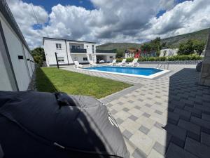 une cour arrière avec une piscine et une maison dans l'établissement Villa Sara, à Blagaj 17 autres photos