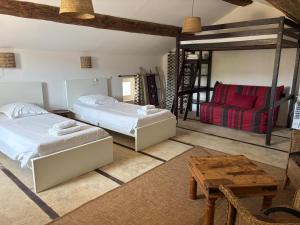 a bedroom with two beds and a red couch at Mas la Provinciale in Malaucène