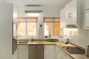 a kitchen with white cabinets and a sink at No 25, in Marsaskala