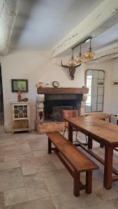 a living room with a table and a fireplace at Mas la Provinciale in Malaucène +31 photos