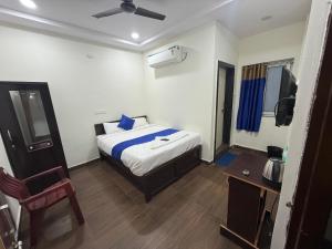 a bedroom with a bed and a chair and a television at COCO NET Hotel in Ibrāhīmpatan