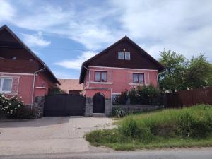 a red brick house with a black fence at Margit kulcsoshaz in Rareş +2 photos