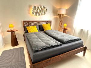 a bed in a room with two tables and two lamps at Am Fluss-Ufer - nur 5 Minuten zum Europapark und direkt am Naturschutzgebiet in Kappel-Grafenhausen